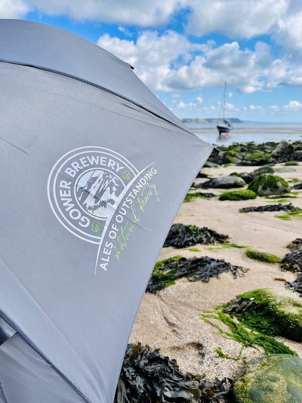 A closeup of the Gower Brewery grey umbrella with a vintage logo